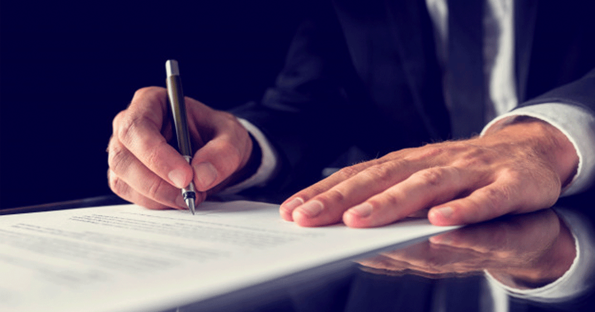 hombre firmando documento
